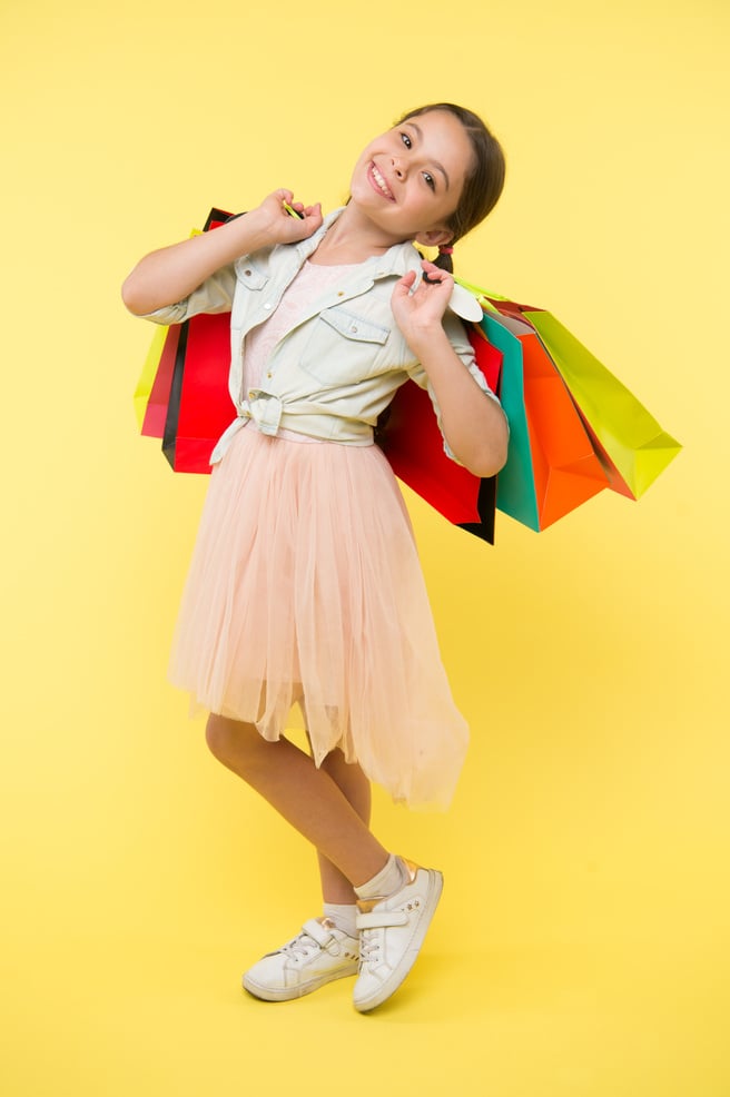 kid in shop. happy kid in shop with bags. beautiful little kid girl in shop. kid shop concept. shopping is the best therapy.